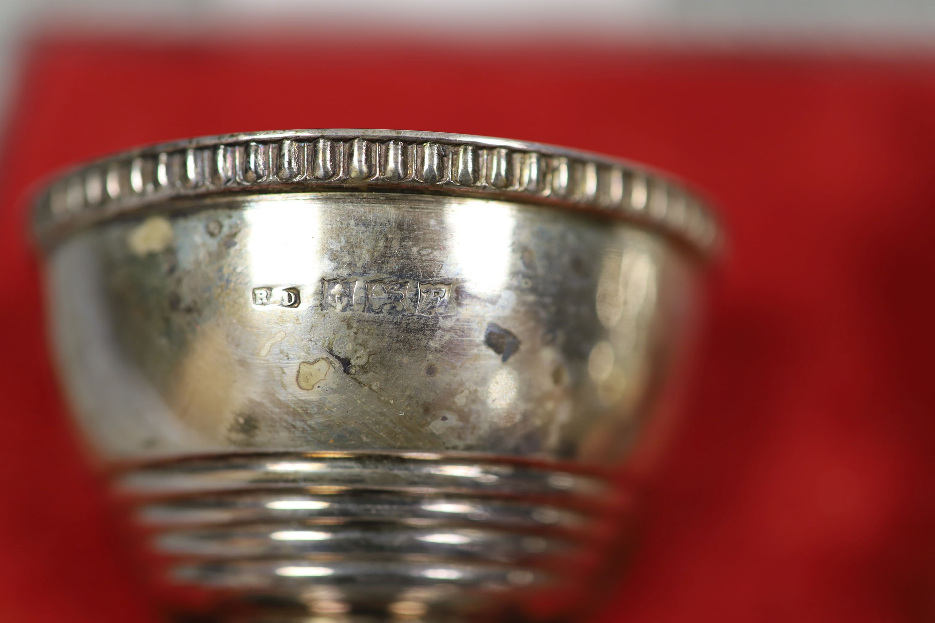 A modern cased silver three piece condiment set, Birmingham, 1955/7, with two associated spoons.